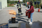 Zwei junge Frauen löschen Feuer mit Feuerlöscher