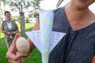 Eierflugmaschine und Ei werden von einer Schülerin präsentiert.