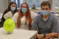 Drei Personen sitzen am Tisch