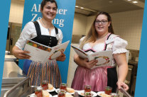 Zwei Schülerinnen halten Kochbuch in den Händen